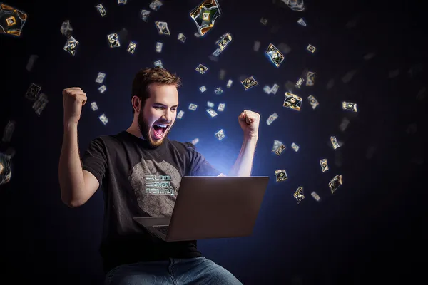 A man celebrating a winning moment on his laptop while gaming symbols float around him, capturing the excitement of GRAPWIN games.